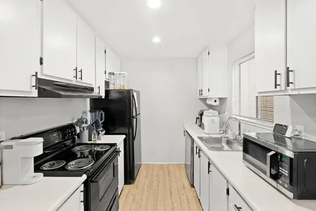 a kitchen with stainless steel appliances a sink stove and cabinets