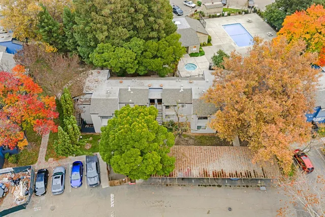 an aerial view of a house with a yard and large tree