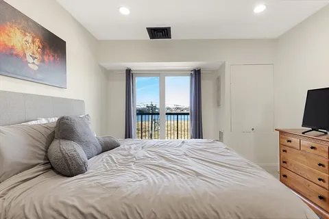 a bedroom with a bed and a flat tv screen on dresser