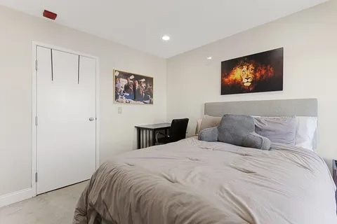 a bedroom with a large bed and a painting on the wall