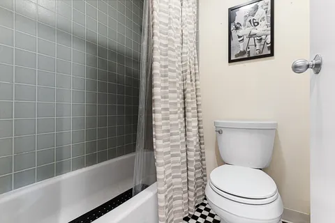 a white toilet sitting next to a bath tub
