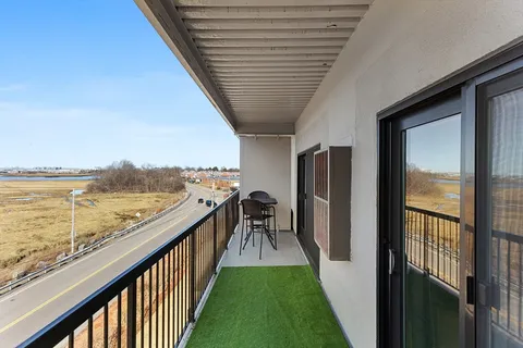 a view of a balcony with furniture and a floor to ceiling window