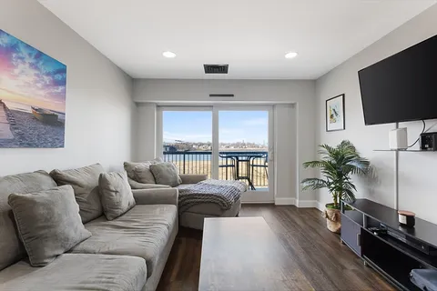 a living room with furniture a large window and a flat screen tv