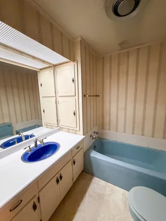 a bathroom with a granite countertop sink and a bathtub
