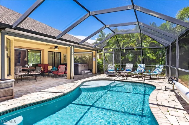 a view of a backyard with swimming pool and sitting area
