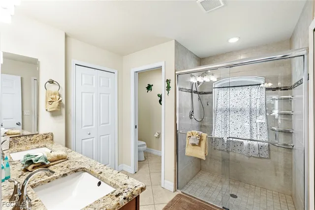 a en suite bathroom with a shower sink and mirror