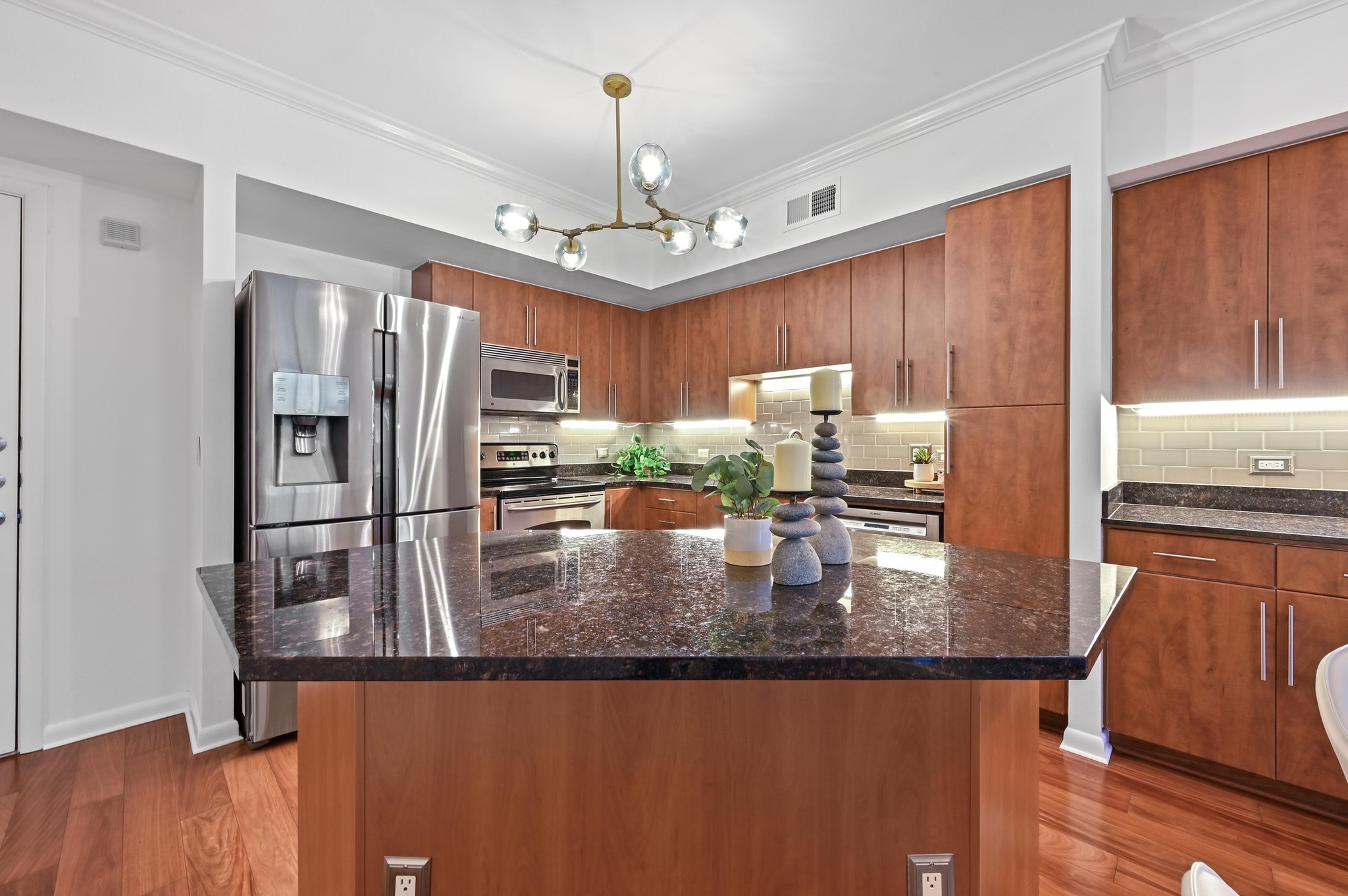 54 Rainey Street, Unit 412 Austin, TX 78701 - Photo 3 of 37 Kitchen with tasteful backsplash, under cabinet lighting, granite counters, appliances with stainless steel finishes, and crown molding