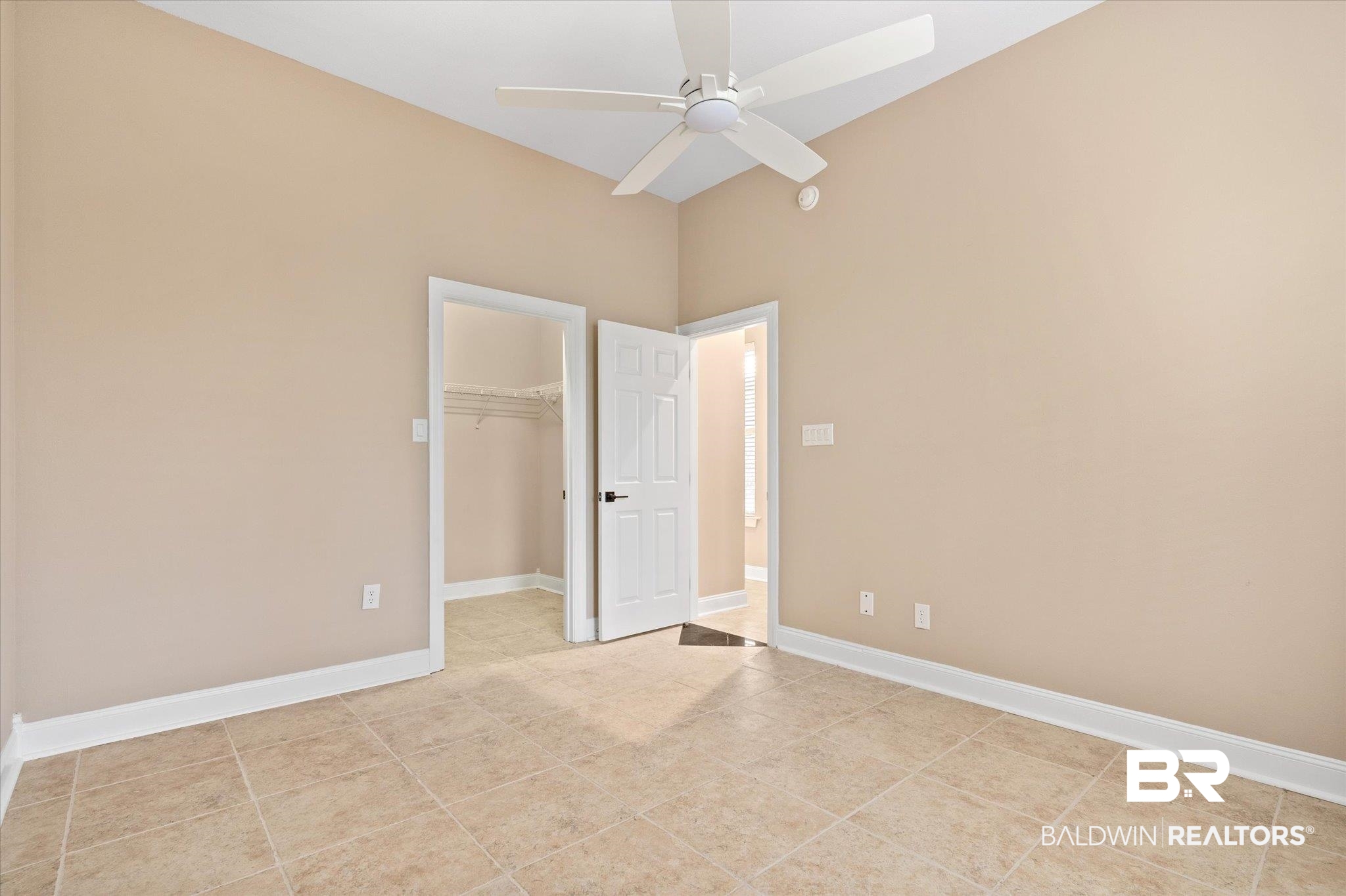 9259 Genipa Way Gulf Shores, AL 36542 - Photo 34 of 72 Unfurnished bedroom featuring a closet, a spacious closet, light tile patterned flooring, and ceiling fan