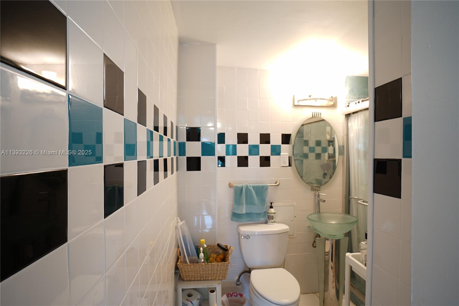3801 Indian Creek Drive, Unit 201 Miami Beach, FL 33140 - Photo 11 of 27 a bathroom with a toilet sink and mirror