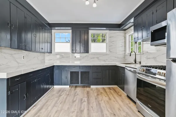 a kitchen with stainless steel appliances granite countertop a stove a sink and a microwave