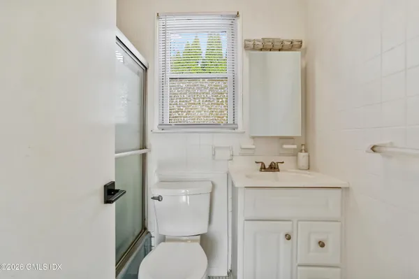 a bathroom with a toilet sink and mirror