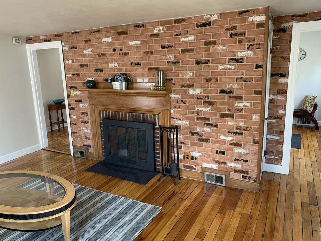 86 Russell Street Springfield, MA 01104 - Photo 5 of 23 a living room with a fireplace and a wooden floor