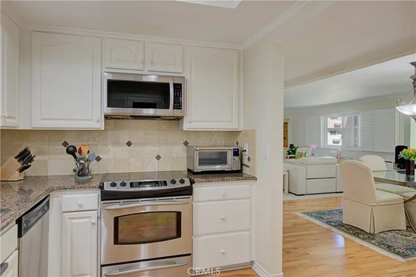 a kitchen with stainless steel appliances granite countertop a stove microwave and cabinets