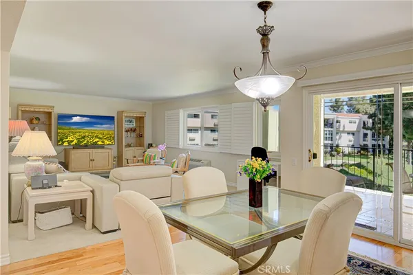 a living room with furniture a chandelier and a dining room