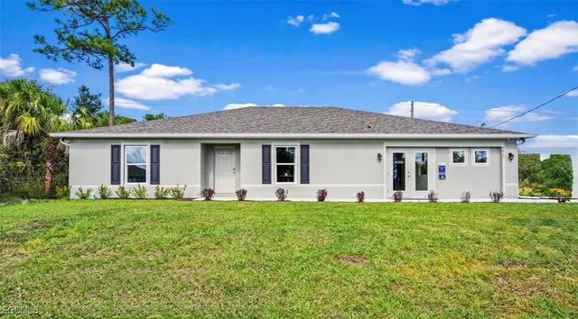 a front view of house with a garden and trees
