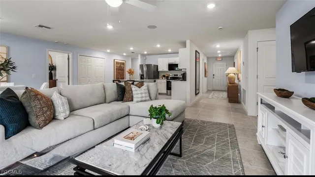 a living room with furniture and a view of kitchen