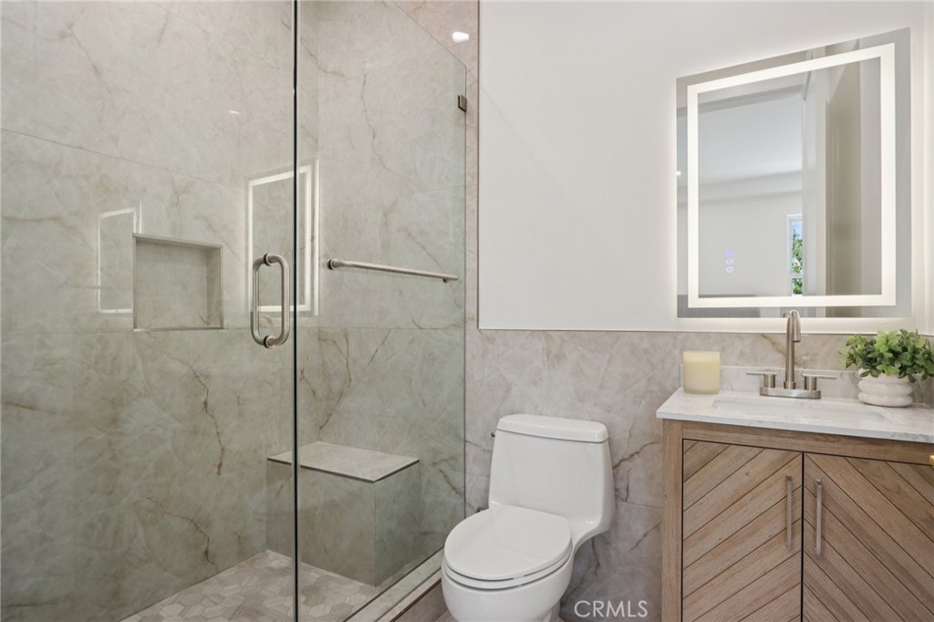 14929 Vose Street Van Nuys, CA 91405 - Photo 14 of 56 a bathroom with a toilet sink vanity and shower