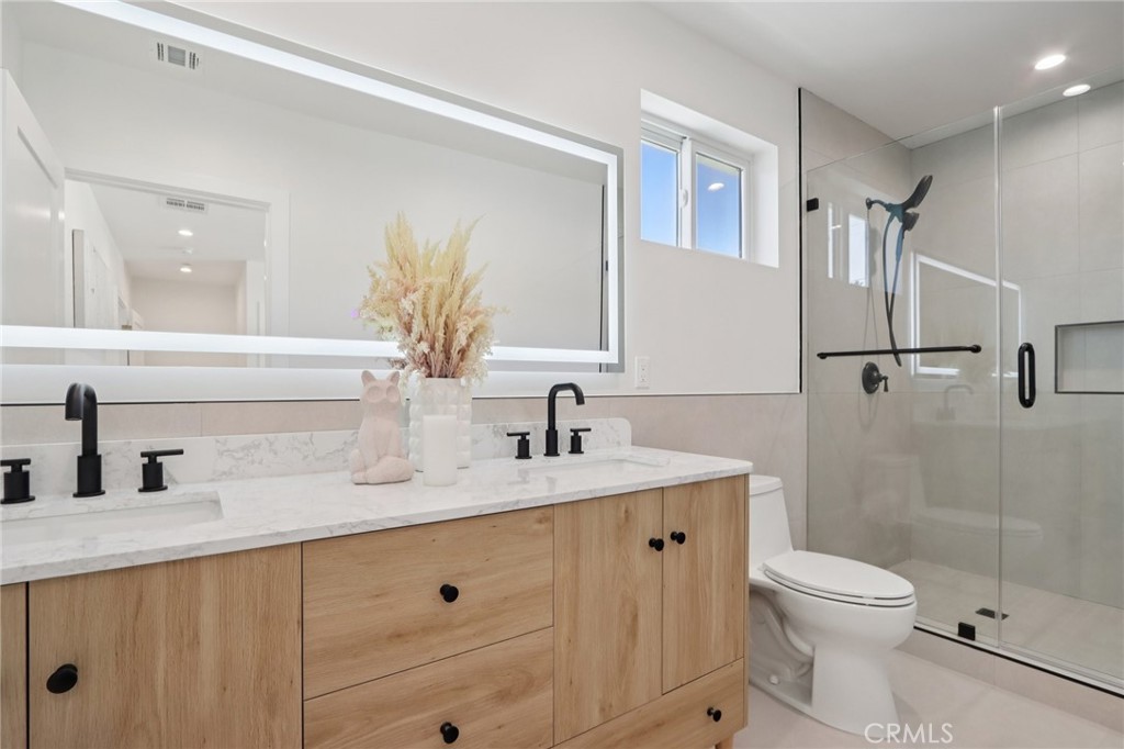 14929 Vose Street Van Nuys, CA 91405 - Photo 20 of 56 a bathroom with a double vanity sink toilet and shower