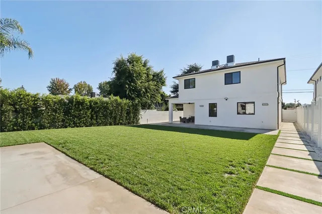 a view of a house with backyard and sitting area