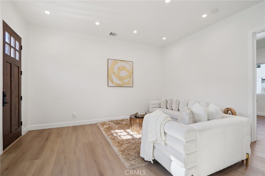 14929 Vose Street Van Nuys, CA 91405 - Photo 36 of 56 a living room with furniture and a baby crib with wooden floor
