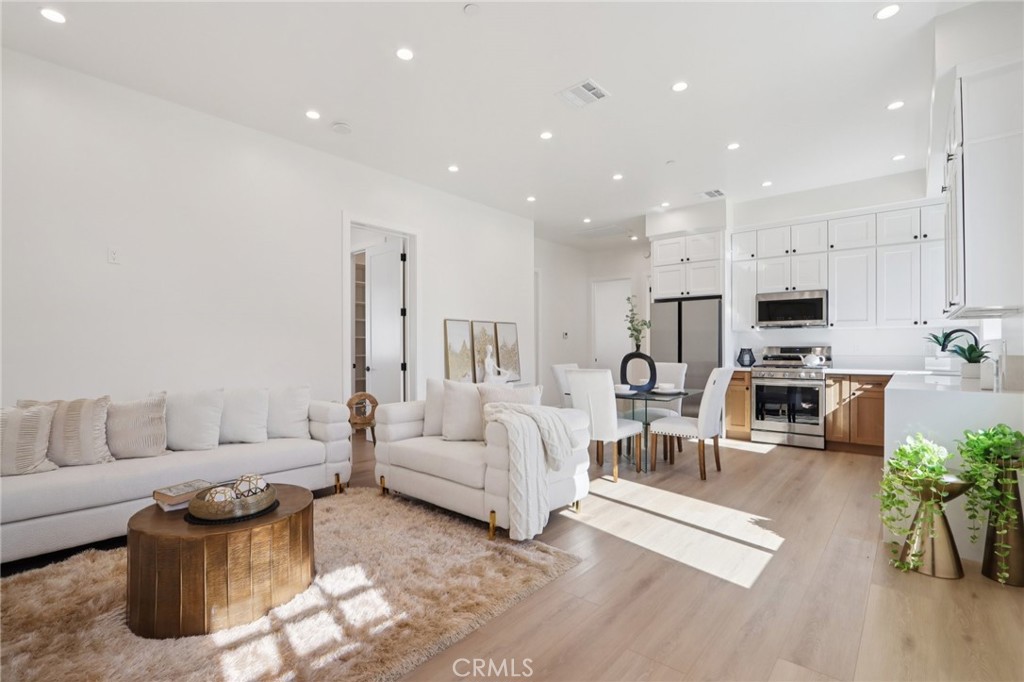 14929 Vose Street Van Nuys, CA 91405 - Photo 37 of 56 a living room with furniture white walls and kitchen view