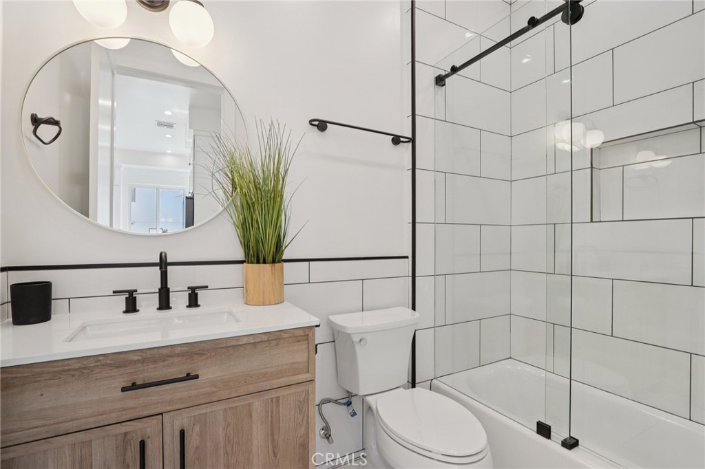 14929 Vose Street Van Nuys, CA 91405 - Photo 40 of 56 a bathroom with a sink a mirror a toilet and shower