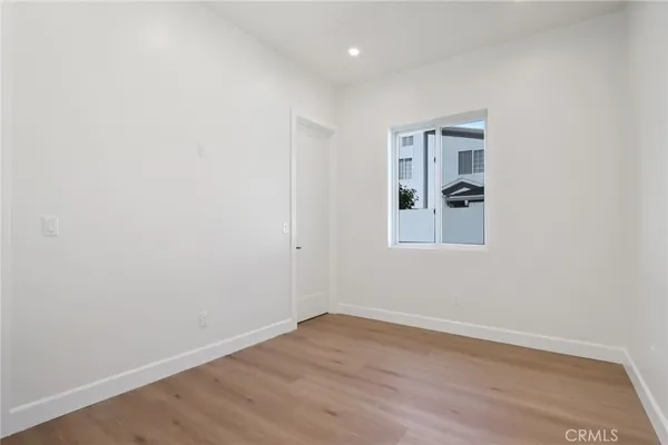 an empty room with wooden floor and window