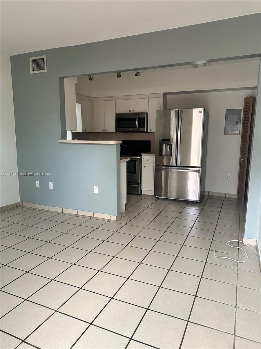 7075 Southwest 14th Street, Unit 1 Miami, FL 33144 - Photo 4 of 10 a kitchen with stainless steel appliances a refrigerator and a stove top oven