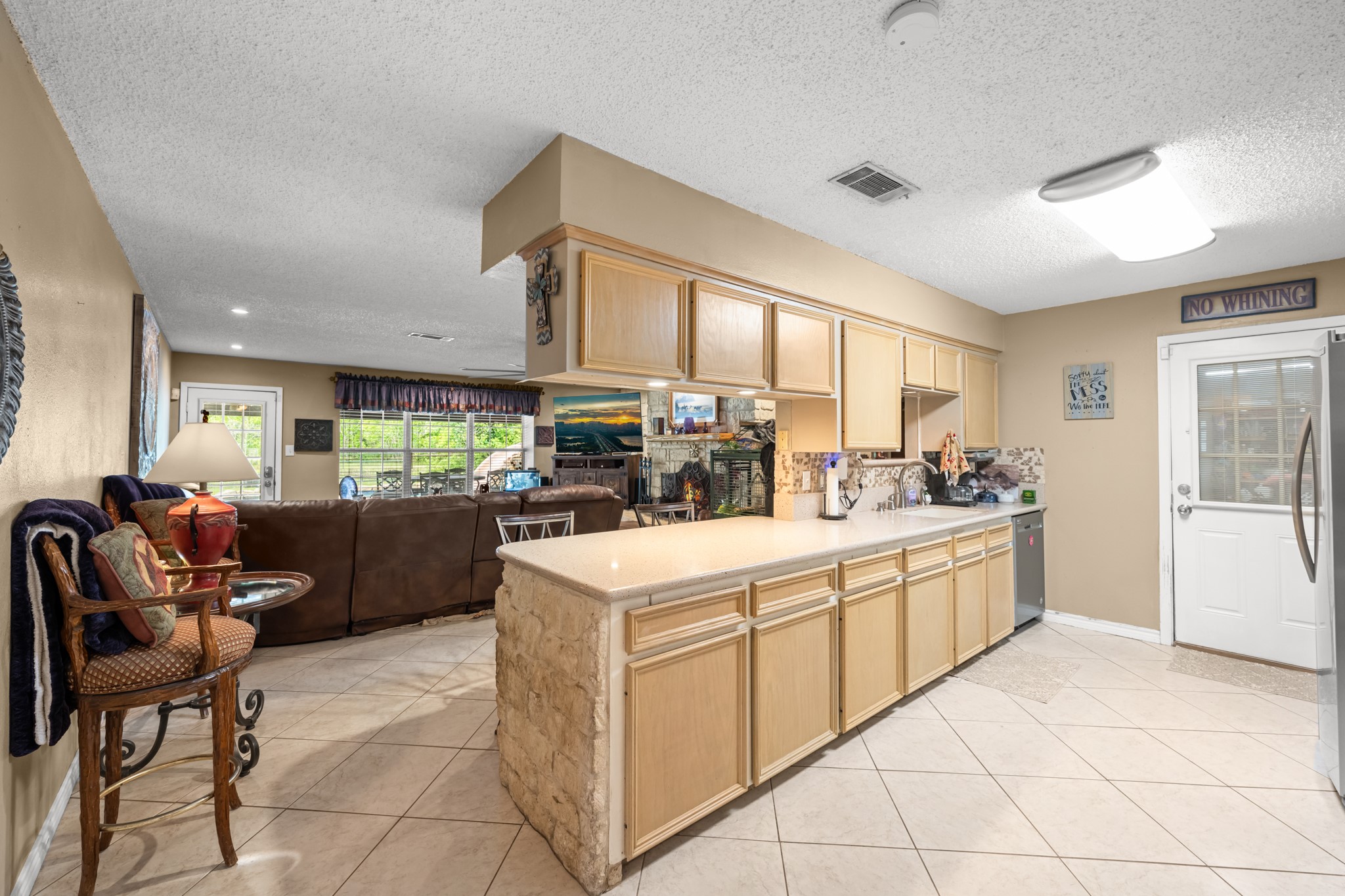 15602 Fir Road Santa Fe, TX 77517 - Photo 7 of 42 Spacious open-concept kitchen featuring extensive cabinetry, expansive counter space, and seamless flow into the living area. The functional layout, tile flooring, and breakfast bar design make this space ideal for both everyday living and entertaining.