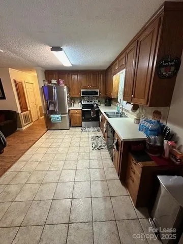a kitchen with stainless steel appliances a sink stove and cabinets