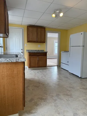 a large kitchen with a refrigerator a stove top oven a sink and dishwasher