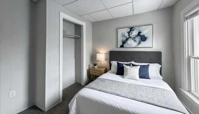 a bedroom with bed and wall painting