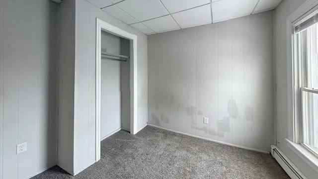 an empty room with windows and closet