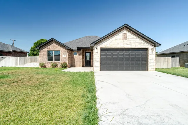 a view of a house with a yard and garage