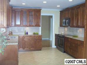 14540 Cabarrus Station Road Midland, NC 28107 - Photo 3 of 8 a kitchen with kitchen island granite countertop a sink cabinets and stainless steel appliances