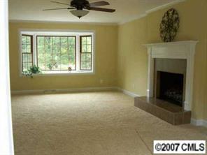 14540 Cabarrus Station Road Midland, NC 28107 - Photo 4 of 8 a view of an empty room with a fireplace and a window