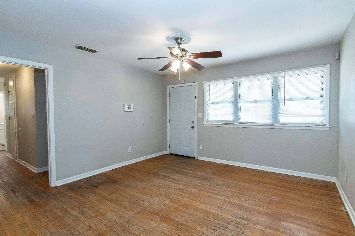 4212 42nd Street Lubbock, TX 79413 - Photo 2 of 18 an empty room with wooden floor chandelier fan and windows