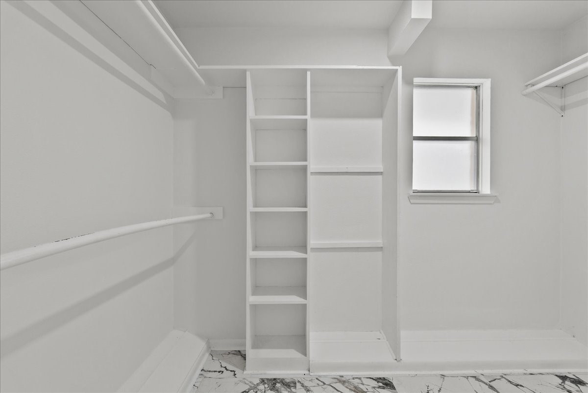 5762 Birdwood Road Houston, TX 77096 - Photo 29 of 50 PRIMARY BEDROOM LARGE WALK IN CLOSET WITH BUILT IN SHELVES TO ADDED VERSATILITY.