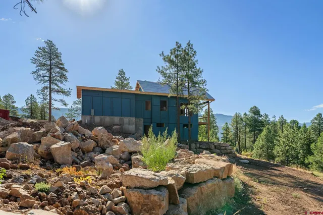 a view of a chairs and flower plants in front of house