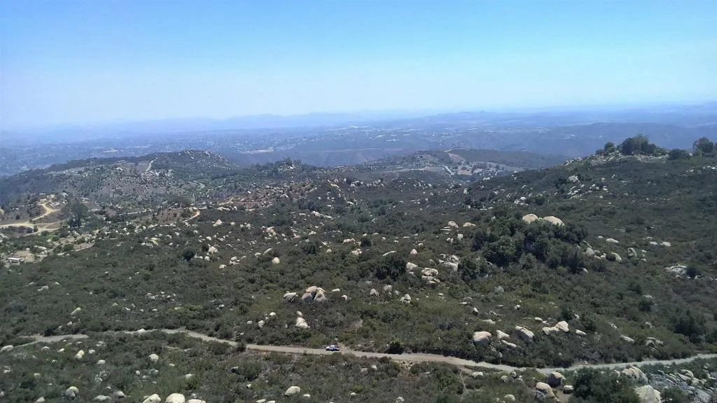 an aerial view of house with yard and mountain view in back