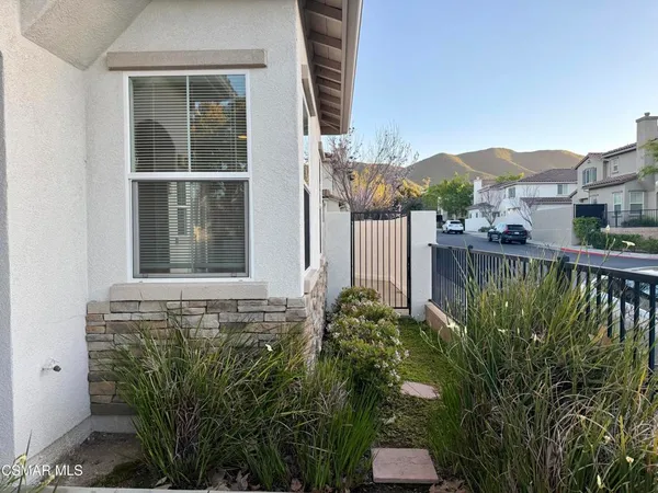 front view of a house with a large window and potted plants