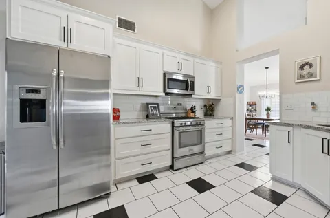 a kitchen with stainless steel appliances cabinets and a window