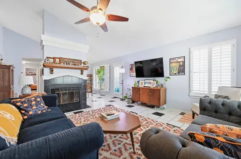 a living room with furniture a flat screen tv and a fireplace