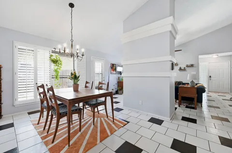 a view of a dining room with furniture and a chandelier