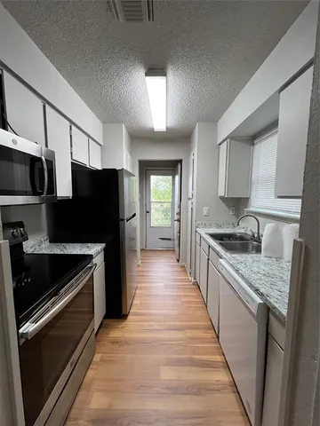 a large kitchen with a stove and a refrigerator