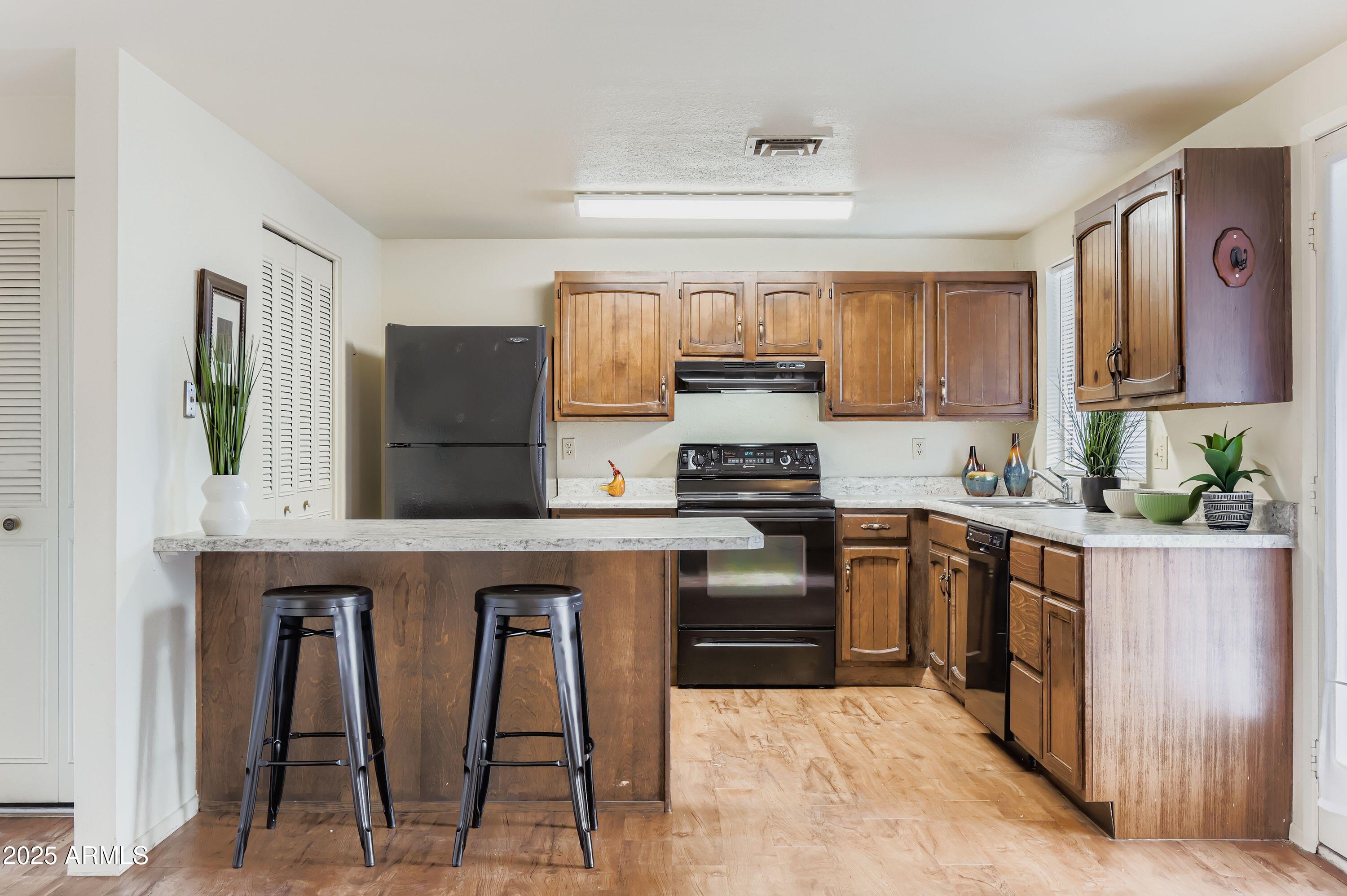 1619 West El Alba Way Chandler, AZ 85224 - Photo 11 of 26 a kitchen with stainless steel appliances granite countertop a stove a sink and a refrigerator