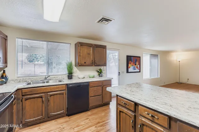 a kitchen with granite countertop cabinets stainless steel appliances a sink and a window