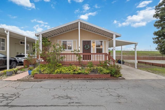 a front view of a house with a garden and plants