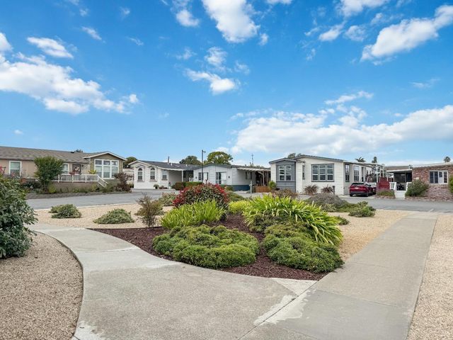 a backyard of a house with barbeque oven and table