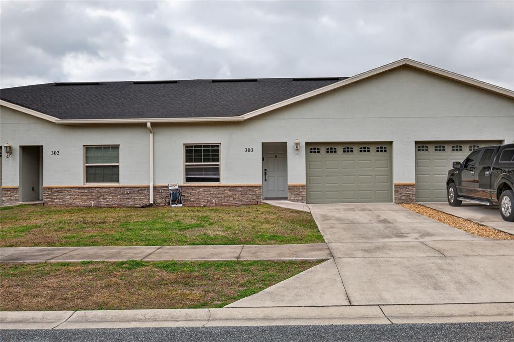 3415 West Anthony Road, Unit 303 Ocala, FL 34475 - Photo 1 of 29 a front view of a house with a yard and garage